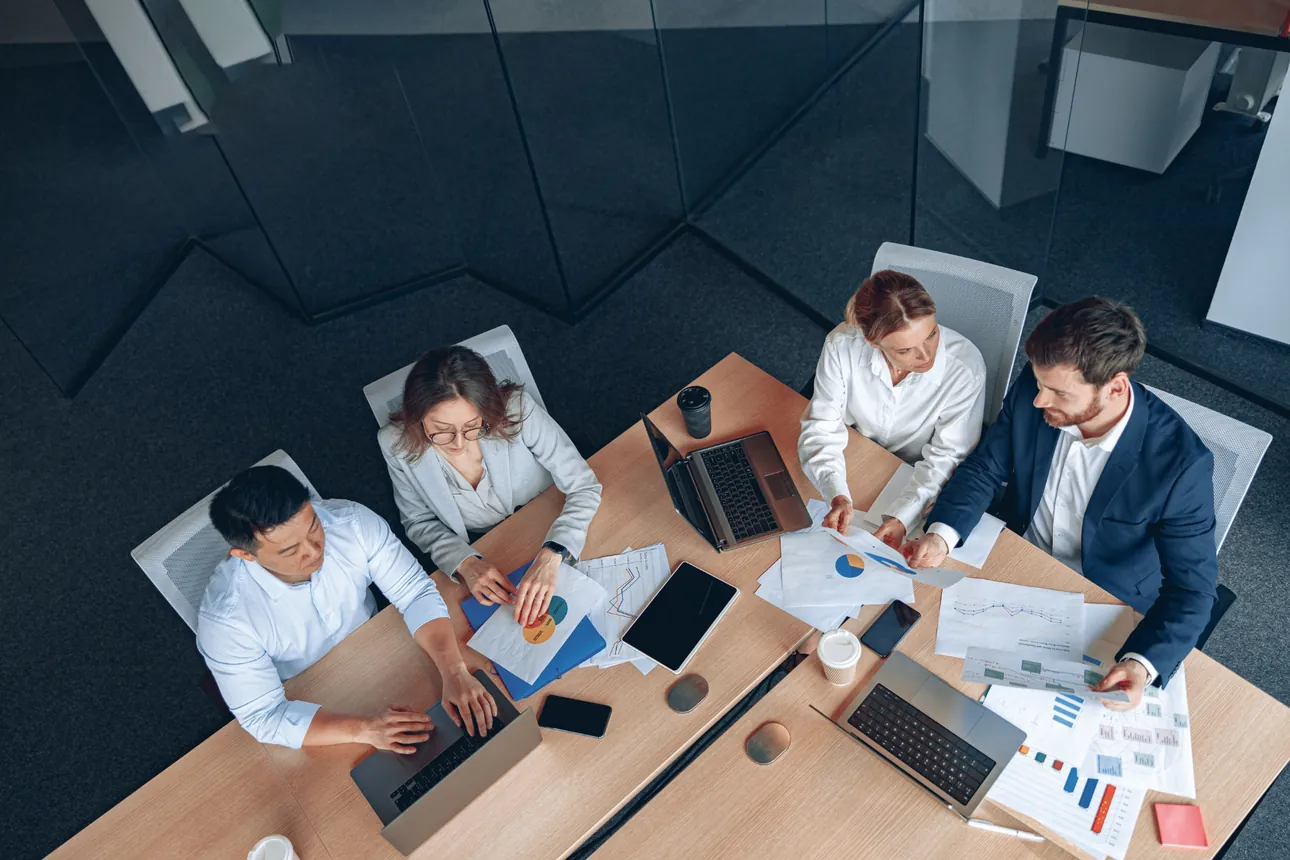 Team working around a meeting table, aerial view